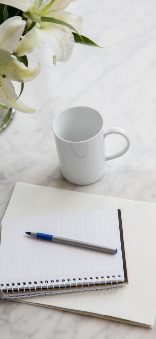 Pen and paper with a coffee mug